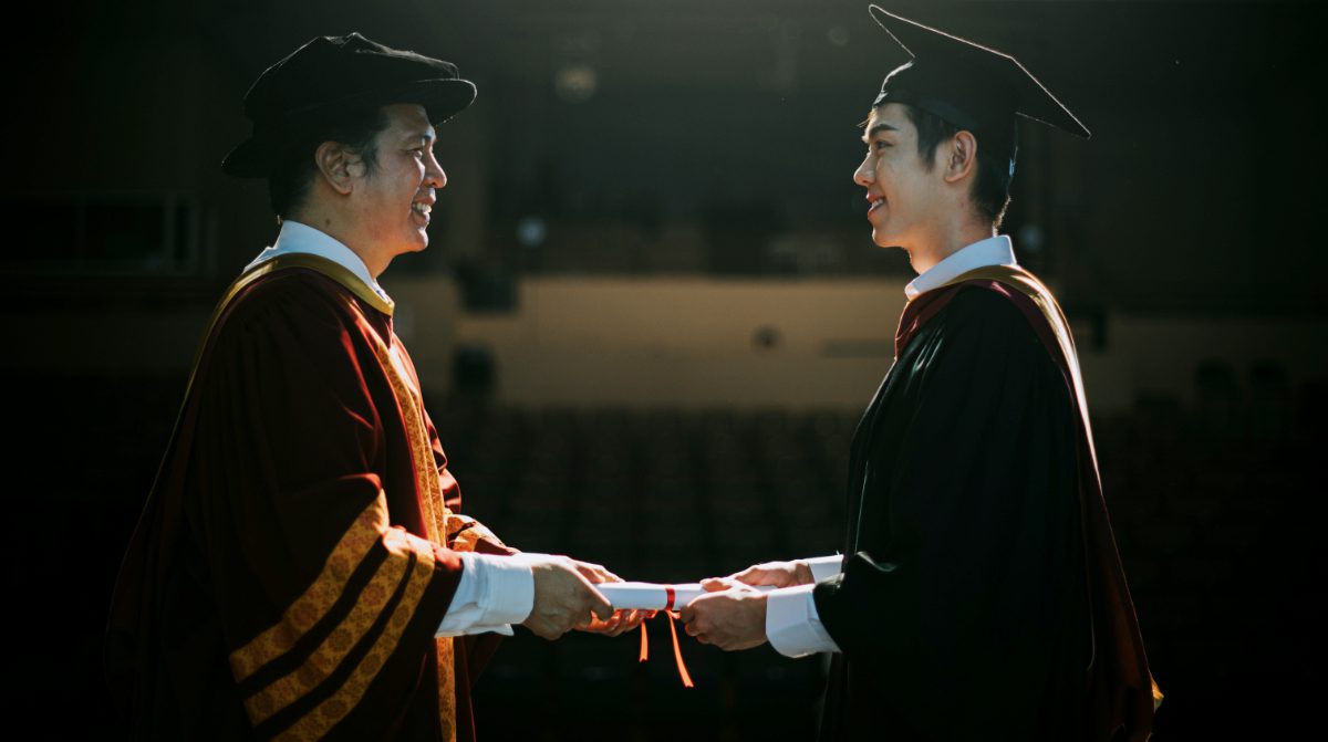 Award ceremony Dean hands over Graduation university student graduation scroll on auditorium stage