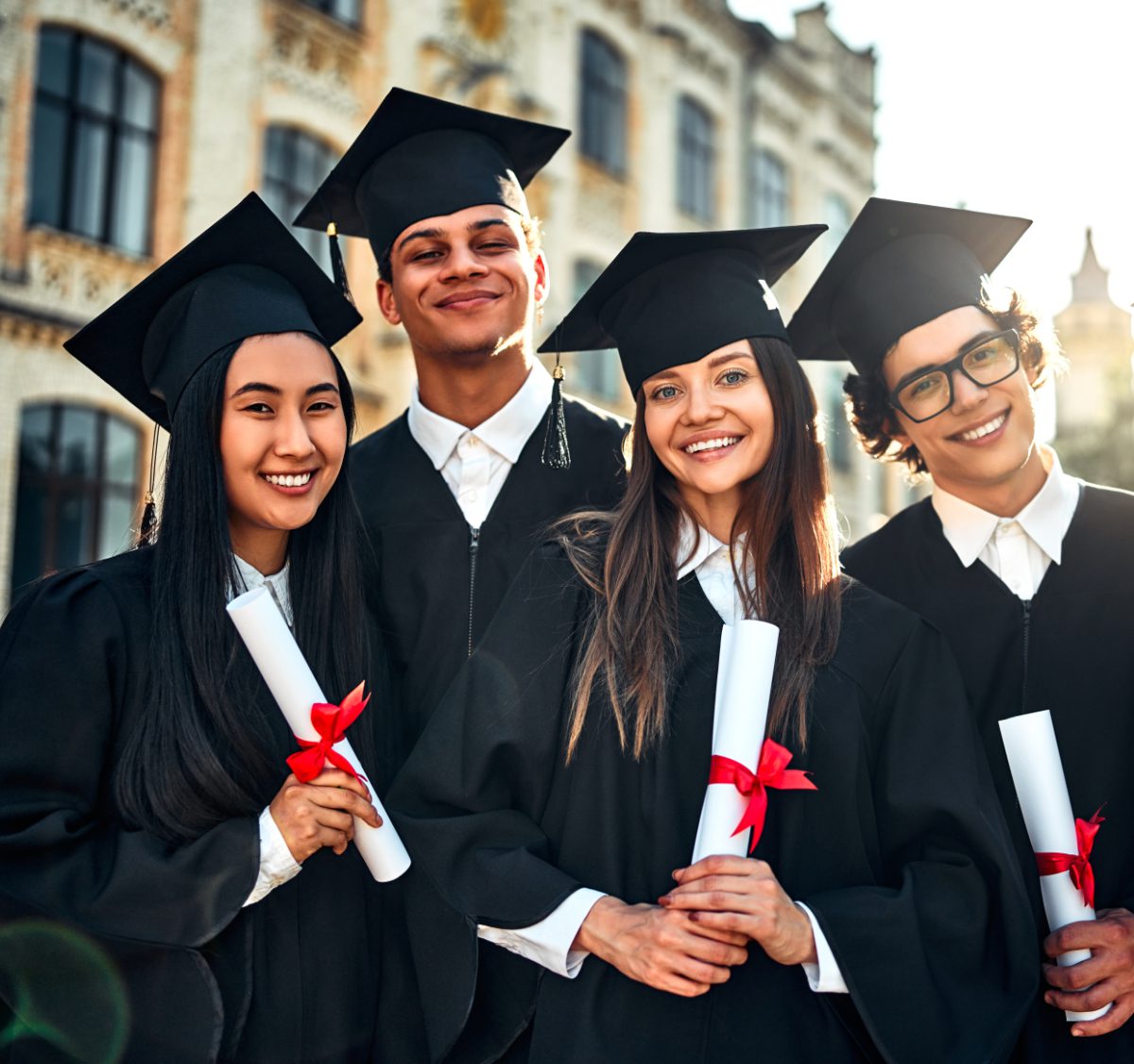 Portrait of beautiful smiling graduates celebrating graduation and holding certificates with academic goals achieved. Successful studies and a bright future.