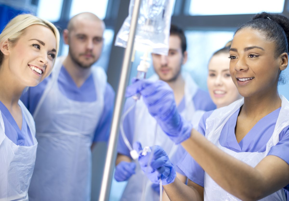 Student nurse shows other trainees how to use the IV drip